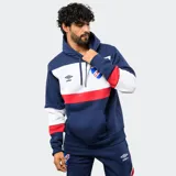 Canguro con capucha de la marca Umbro, oficial del Club Nacional de Football. Presenta un diseño tricolor con bloques en rojo, blanco y azul, bolsillo frontal tipo canguro y cordones ajustables en la capucha.