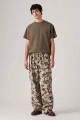 Pantalón cargo de corte amplio con estampado de camuflaje en tonos beige, marrón y verde. Cuenta con cintura elástica ajustable con cordón, bolsillos laterales con solapa y bolsillos traseros.