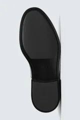 Zapato de vestir tipo derby color negro acharolado, con horma en punta y suela con ligero tacón.