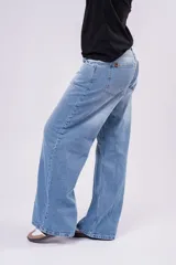 Pantalón de jean tiro bajo con corte wide leg y lavado celeste vintage. Presenta un diseño de pernera ancha y recta, con cierre de botón y cremallera, y bolsillos laterales y traseros.
