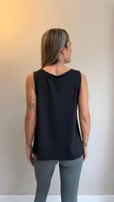 Musculosa deportiva negra de corte holgado, con cuello redondo y aberturas laterales que brindan mayor libertad de movimiento.
