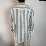 Camisa celeste y blanca a rayas verticales, de lino, con cuello mao y mangas largas con puños.