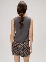 Musculosa MUTMA Trebola de silueta recta confeccionada en tejido de punto color gris con efecto lavado. Posee cierre frontal con botones, detalle de bordado en el pecho y terminación festoneada en el ruedo y las sisas.