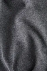 Top de punto fino color gris oscuro, con cuello redondo acanalado, mangas cortas tipo raglán y silueta acampanada (peplum).