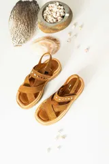 Sandalias de cuero marrón con textura de cocodrilo, diseño de tiras cruzadas con tachas metálicas plateadas y suela track negra de plataforma.
