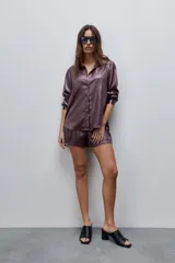 Short de tiro alto con silueta amplia, confeccionado en tela de acabado brillante y textura arrugada.