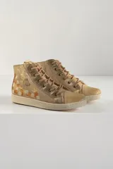 Botas de caña alta de cuero vacuno en color beige con brillos suaves y detalles pintados a mano por Carolina De Cunto, con cordones y suela de goma.