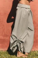 Pantalón culotte de tiro medio con cintura elástica, bolsillos laterales ocultos y bajo con abertura ajustable mediante cordones laterales.