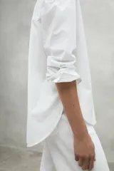 Camisa blanca de lino, de corte holgado, con cuello clásico y botones frontales.