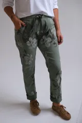 Pantalón de corte recto y tiro medio con estampado floral en tonos verdes. Presenta cintura elástica con cordón de ajuste, bolsillos laterales y dobladillo en los tobillos.