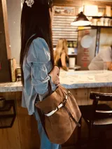 Bolso marrón de cuero gamuzado con correa bandolera de cuero marrón y detalle de cuero con estampado animal print.