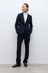 Blazer clásico de corte entallado, color negro, con cierre frontal de un botón, solapas de muesca y bolsillos laterales con solapa.