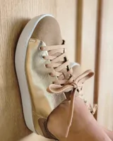 Zapatillas urbanas de cuero color dorado con puntera y talón en gamuza color beige.