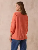 Blusa amarilla texturada con escote redondo y mangas 3/4 con puño elastizado. Aplique de broderie en escote y mangas. Marca Ruby Rd.