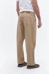 Pantalón de corte relajado y silueta amplia, confeccionado en algodón con acabado lavado. Presenta un diseño clásico de cinco bolsillos, cierre frontal con botón y costuras laterales reforzadas.