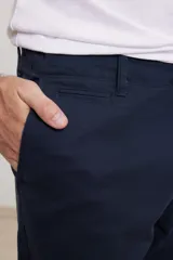 Pantalón chino de hombre color verde oscuro, corte slim, confeccionado en algodón con elastano, con triple pespunte en las costuras y botones al tono.