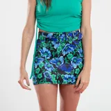 Minifalda negra con estampado floral en tonos azul y verde, con cinturón con hebilla metálica.