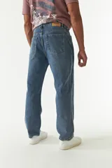 Jean de corte baggy con tiro medio, diseño amplio en piernas y cadera, con cierre y botón frontal.