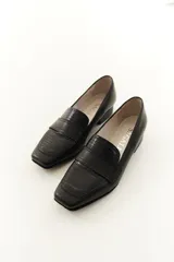 Mocasines de cuero vacuno color beige con textura efecto cocodrilo, punta cuadrada y taco bajo.