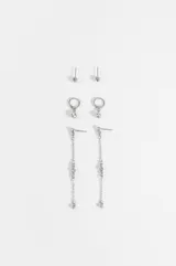 Set de tres pares de caravanas plateadas con incrustaciones de strass. Incluye un par de puntos de luz, un par de argollas pequeñas con dije colgante y un par de caravanas largas con cadena fina y strass.