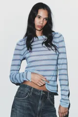 Jersey de manga larga con cuello redondo, color celeste con rayas finas en azul y marrón.