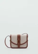 Bolso bandolera de diseño estructurado con cuerpo de tejido efecto rafia en color beige y detalles de ribetes y correa en cuero sintético color marrón. Presenta una solapa frontal con cierre de hebilla decorativa y botón magnético, y una correa larga ajustable para llevar al hombro o cruzado.