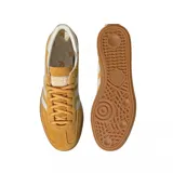 Championes adidas Handball Spezial de diseño retro, confeccionados en gamuza color mostaza con las icónicas tres tiras laterales en blanco. Presentan una suela de goma natural y detalles en blanco en el talón.