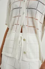 Camisa blanca de manga corta con botones en el frente, corte cuadrado y calce cómodo.