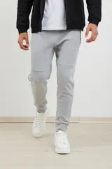 Pantalón jogging de corte slim, con puños elastizados, cintura con cordón ajustable, cierres laterales engomados y bolsillo tipo parche lateral.