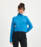Blusa de punto color azul, con cuello alto y manga larga. Diseño básico de corte recto y textura suave.