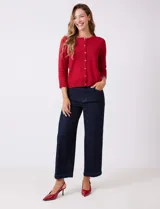 Cardigan de tejido fino en color gris, con cuello redondo, cierre frontal con botones y mangas tres cuartos.