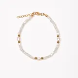 Pulsera dorada con cuentas de piedra blanca y perlas.