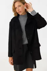 Tapado negro con cuello solapa, de corte recto y largo hasta la rodilla.