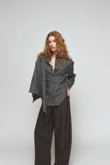 Camisa oversize de algodón con estampado de cuadros, cuello solapa, manga larga con puños y cierre frontal con botones. Presenta un detalle de pañuelo integrado en el mismo tejido que se anuda en la parte frontal.