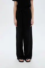 Pantalón negro de poliéster, con bolsillos laterales, tiro alto y diseño ancho.