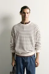 Jersey de punto regular fit, color blanco con rayas horizontales negras, de cuello redondo y manga larga con terminaciones en rib.