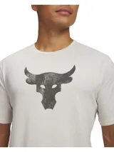 Remera de manga corta color beige con cuello redondo acanalado. Presenta un estampado frontal en color gris oscuro con el logo del toro de la colección Project Rock.