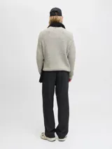 Sweater de punto con cuello redondo y manga larga, de calce holgado. Presenta textura acanalada y puños elásticos, confeccionado en un tejido melange de tono claro.