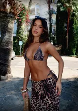 Conjunto de bikini con estampado animal print, compuesto por un corpiño triangular con tirantes finos y una falda larga de corte recto con abertura lateral.