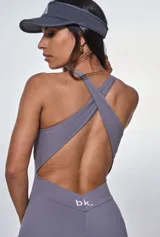 Catsuit deportivo gris con escote halter y cordones ajustables en el pecho.