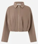 Campera corta de algodón con felpa, diseño tipo baloné con cuello clásico y cierre frontal de cremallera metálica. Presenta un corte holgado y estructura uniforme.