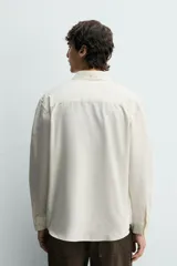 Camisa regular fit de color celeste, confeccionada en tejido con mezcla de algodón y seda, con cuello solapa, manga larga con puño abotonado y cierre frontal de botonadura.