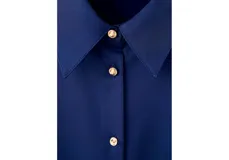 Camisa de satén azul satinado con cuello camisero, manga larga y cierre frontal de botones.