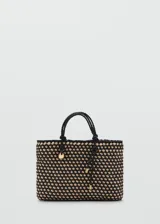Bolso tipo tote confeccionado con un diseño trenzado en colores negro y beige. Cuenta con doble asa de mano trenzada y detalles metálicos dorados.