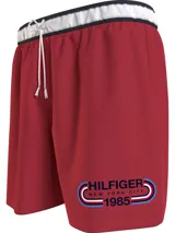 Short de baño rojo con cintura elástica blanca, cordón ajustable y logo de Tommy Hilfiger estampado en la pierna derecha.
