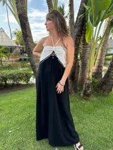 Vestido largo de breteles con parte superior blanca y falda negra. Presenta detalle de tachas plateadas en el borde de la parte superior.