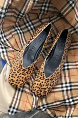 Zapato plano tipo ballerina con escote en V y punta cuadrada, confeccionado en cuero con estampado animal print de leopardo.