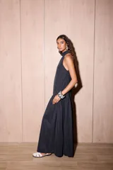 Vestido largo negro de crepe texturado con escote halter, cuello alto con volados y diseño holgado.