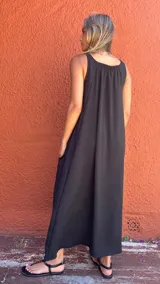 Vestido largo negro de seda opaca, con bolsillos laterales, corte en A y diseño con cortes laterales en la espalda.