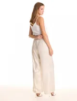 Pantalón wide leg de tela laminada metalizada color blanco, con pretina elástica y lazo de ajuste en la cintura. Cuenta con bolsillos laterales.